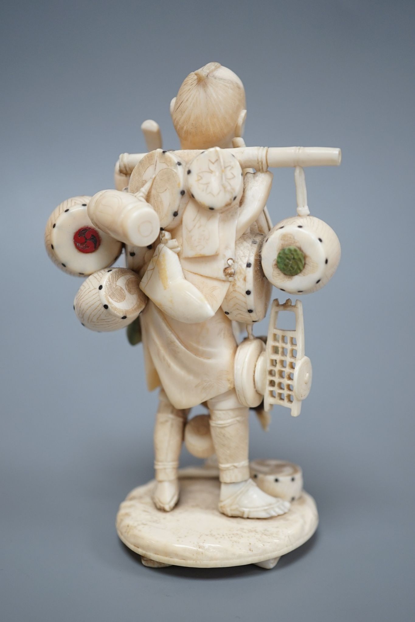 A Japanese ivory okimono of a street vendor, early 20th century 12cm